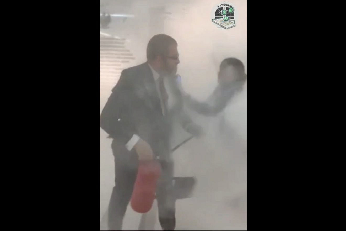 A far-right member of Poland’s Parliament, Grzegorz Braun, extinguishes a Chanukah menorah (injuring a woman) on Dec. 12, 2023. Credit: Chabad of Poland.